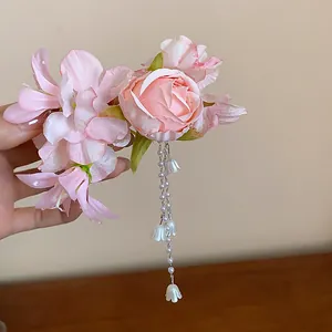Exquisite pink cloth flower hair clip featuring long pearl tassels and bell charms.