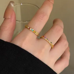 Close-up view of elegant gold stacking rings with colorful zircon and rainbow dots detail