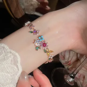 Primer plano de una pulsera bañada en oro de 18k con flores de circón y perlas