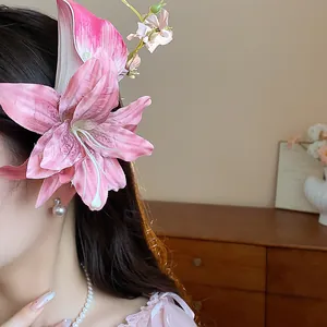 Close-up of pink fabric lily flower hair clip showing delicate petal texture.