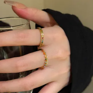Macro view showing the fine details of colorful zircon gold stacking rings on fingers