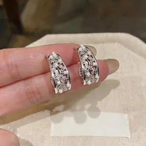 Elegant hollow C-shaped silver stud earrings with pearl inlay detail