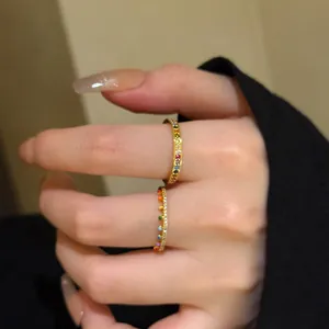Detailed view of slim gold stacking rings with multi-colored rainbow zircon stones