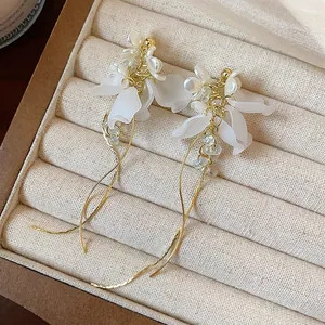 Elegant floral pearl tassel earrings in gold finish displayed inside a jewelry box