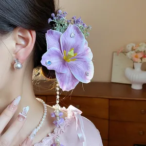 Detailed view of elegant purple fabric flower hair clip with long pearl tassels