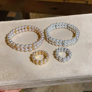 Double-layer pearl bracelets and rings in gold and silver plating on velvet surface.