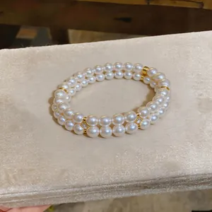 Elegant double-layered pearl bracelet with 18K gold-plated spacers on beige velvet