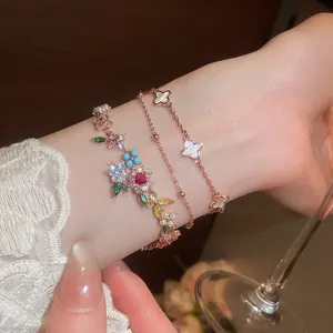 Detalle de pulsera bañada en oro de 18k con flores de circón y tréboles