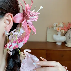 Detailed view of elegant pink fabric flower hair clip with pearl tassel on braided hair