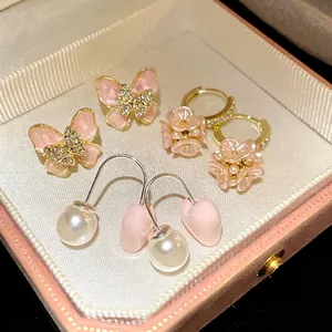 Elegant pink butterfly, flower, and heart pearl earring set showcased in a gift box