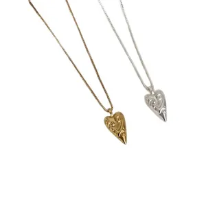 Elegant minimalist gold and silver heart pendant necklaces with engraved swirl patterns.