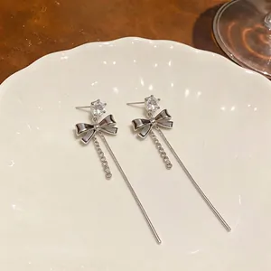 Elegant silver bow earrings with zircon studs and long tassel drops