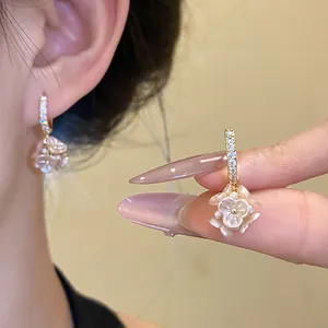 Detailed shot of elegant pink floral pearl hoop earrings with crystal pavé on model