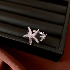 Detailed view of an elegant open ring featuring two sparkling zircon-encrusted starfish.