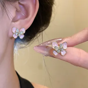 Detailed macro view of pink enamel butterfly stud earrings with shimmering rhinestones
