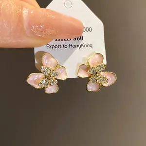 Close-up of elegant pink enamel butterfly stud earrings with sparkling crystal accents