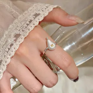 Détail d'une bague réglable en argent en forme de poire avec une pierre de zircon jaune