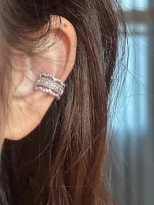 Gros plan d'un ear cuff en zircon argenté avec des bords en dentelle délicats
