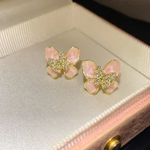 Close-up detail of elegant butterfly stud earrings with pink enamel and sparkling crystals