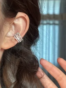 Gros plan détaillé du élégant protège-oreille en dentelle plaqué or 18 carats avec zircones.