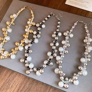 Ensemble de colliers rétro élégants en perles et billes métalliques sur surface grise