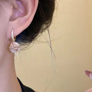 Close-up detail of elegant pink flower cluster hoop earrings worn on ear for women