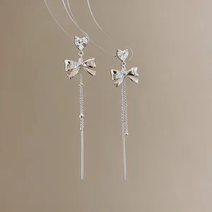 Elegant silver bow earrings featuring heart-shaped zircon stones and long tassel detail