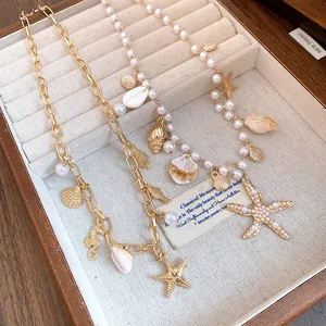 Detailed view of gold-tone marine charm necklaces with pearls and starfish charms.