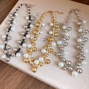 Vue détaillée de colliers de perles vintage avec des grappes de perles dorées et argentées.