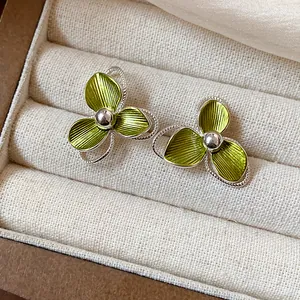 Close-up of green flower earrings with textured petals in a jewelry box