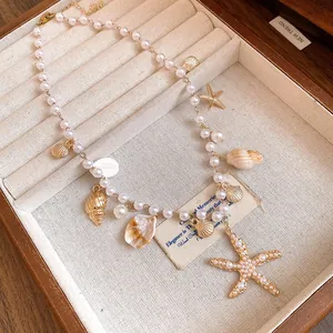 Detailed macro shot of pearl necklace featuring golden starfish and sea shell charms