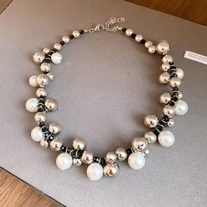 Détail rapproché d'un collier de perles rétro orné de boules argentées et de perles