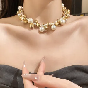 Vue détaillée d'un élégant collier ras-du-cou vintage en perles et billes dorées sur mannequin