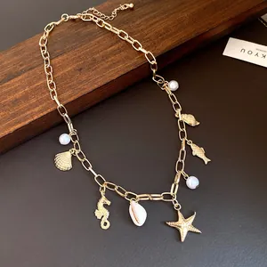 Detailed macro view of a gold ocean-themed charm necklace featuring starfish and white pearls.