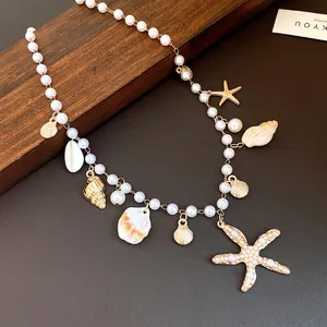 Detail of pearl necklace with starfish, shell, and conch charms on wooden background