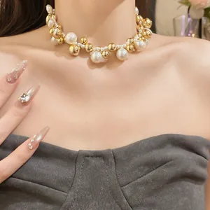 Gros plan détaillé d'un collier ras du cou vintage à perles et billes dorées sur modèle
