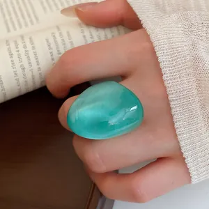 Detailed view of a chunky seafoam green resin ring with elegant pearlescent finish