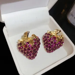 Vintage strawberry stud earrings with pink rhinestones in a white jewelry box