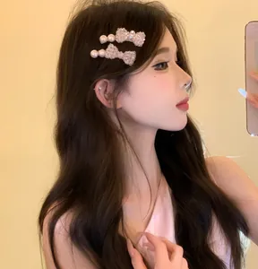 Detailed side view of an Asian model wearing elegant pearl and crystal bow hair clips