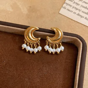 Detail view of vintage gold moon earrings with elegant hanging pearl tassels