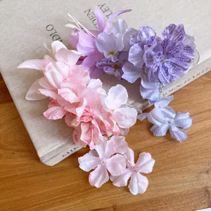 Detailopname van roze en paarse stoffen bloemen haarspelden met fijne hangende kwastjes
