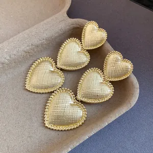 Detailed macro view showing the quilted texture of gold heart tassel drop earrings.