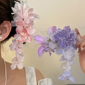 Detailopname van stoffen bloem haarspelden met elegante kwastjes in roze en paars
