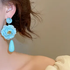 Nahaufnahme von eleganten hellblauen Rosen-Ohrhängern im Vintage-Stil an einem Modell