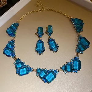 Detailweergave van luxe geometrische blauwe kristallen halsketting en oorbellen sieradenset.