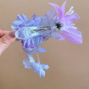 Detailopname van een paarse stoffen bloemenhaarkaart met delicate kristallen kwastjes