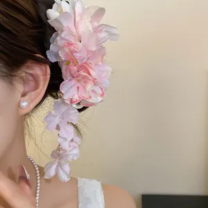 Detail van roze stoffen bloemen haarklem met elegante hangende bloemblaadjes