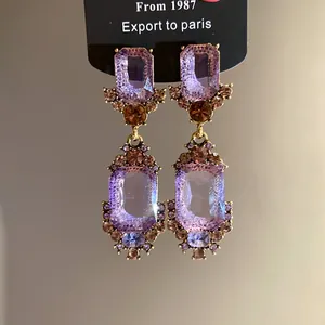 Macro-opname van vintage paleisstijl oorbellen met paarse geometrische vierkante kristallen