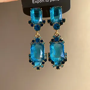 Detailopname van vintage oorbellen met blauwe geometrische kristallen in paleisstijl