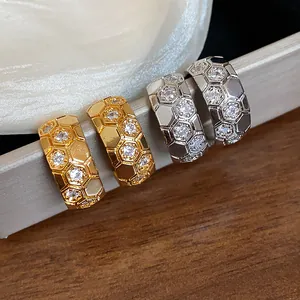 Macro detail of gold and silver C-shaped honeycomb earrings with sparkling cubic zirconia
